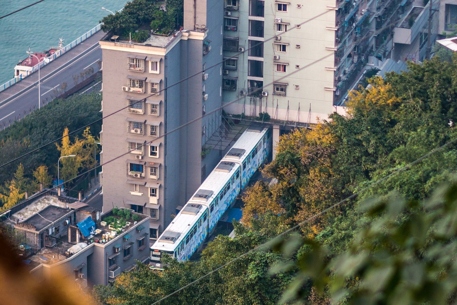 A Line 2 train passing through a residential building at Liziba